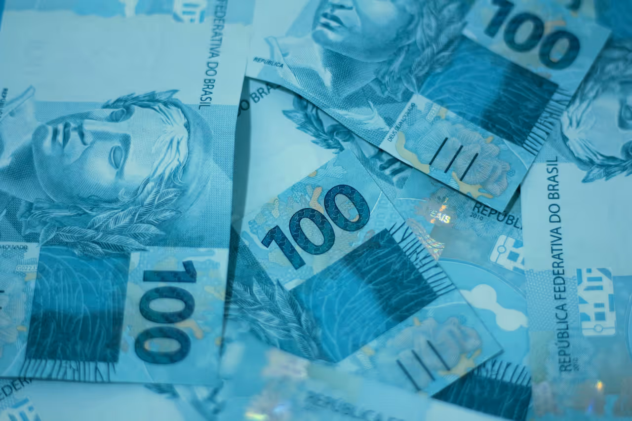 Pilha de notas de dólar representando câmbio e custo de compras internacionais para brasileiros