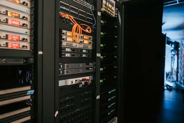 Rack de servidores em data center com iluminação azul — representando infraestrutura de hospedagem profissional para e-commerce