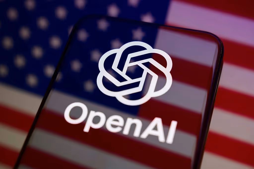 Celular exibe o logotipo da OpenAI diante da bandeira dos Estados Unidos